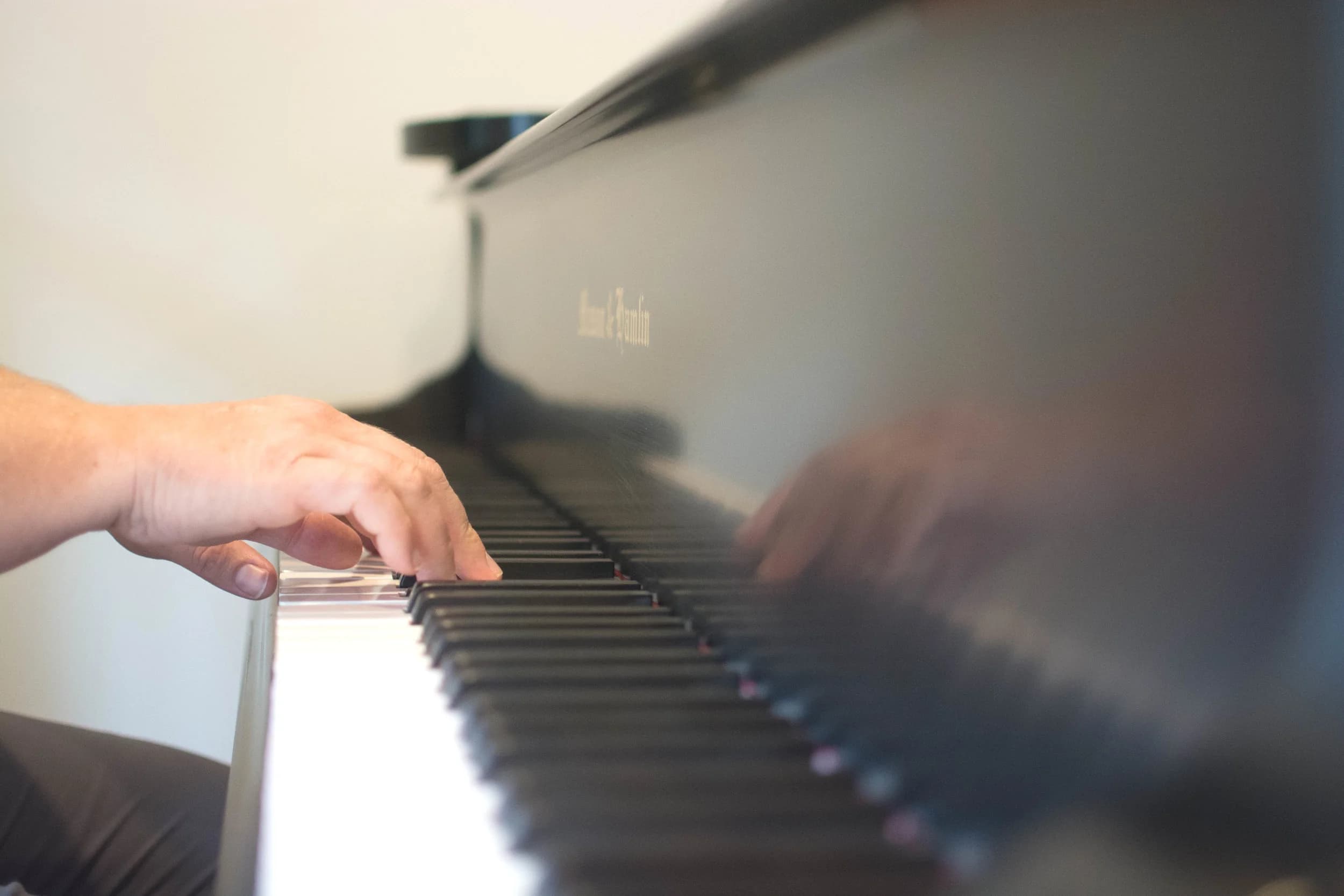 Hands playing a grand piano